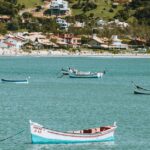 destinos subestimados no Brasil — Idyllic view of boats floating on Garopaba Bay with lush hillside backdrop in Brazil.