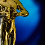 Oscar 2026 — A shining Oscar statuette, symbolizing achievement in the film industry, against a vibrant blue backdrop.