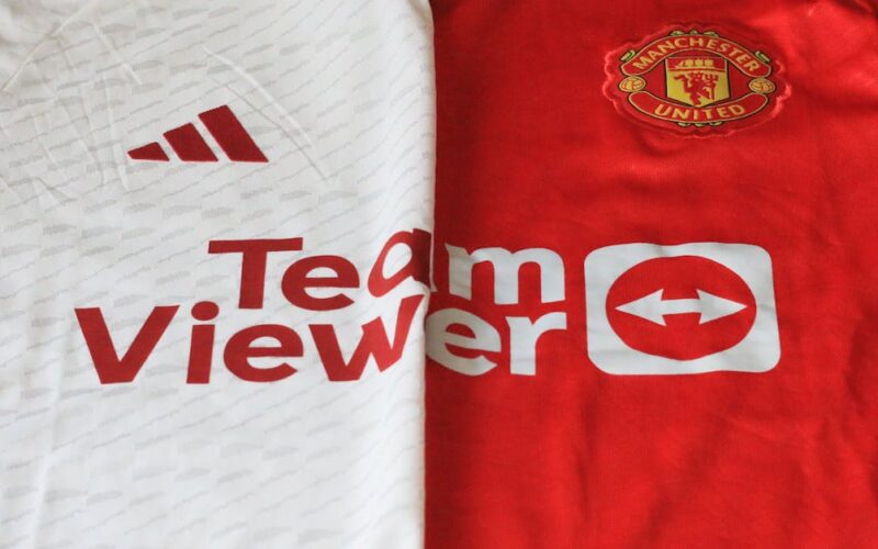 Dinâmicas Premier League — Close-up of Manchester United 2023 jerseys showcasing red and white designs.