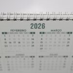 calendário futebol brasileiro 2026 — Close-up of a 2026 spiral-bound desk calendar with months in Portuguese.