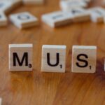 ranking bilionários Elon Musk — Close-up of Scrabble tiles spelling 'MUSK' on a wooden table, ideal for business and innovation themes.