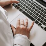 organizar documentos pessoais terceira idade — Woman working on a laptop indoors, focusing on document editing and remote work.