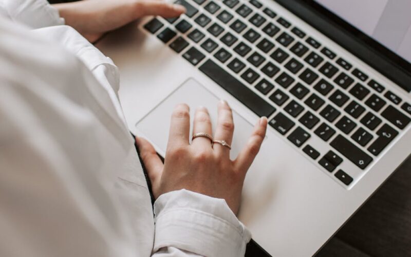 organizar documentos pessoais terceira idade — Woman working on a laptop indoors, focusing on document editing and remote work.