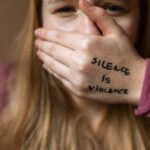 violência doméstica identificar agir — Powerful image highlighting the message 'Silence is Violence' to raise awareness on social issues.