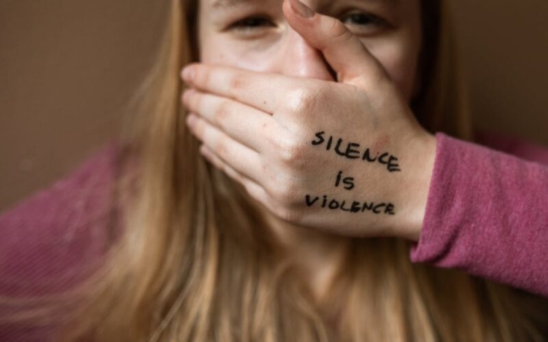 violência doméstica identificar agir — Powerful image highlighting the message 'Silence is Violence' to raise awareness on social issues.