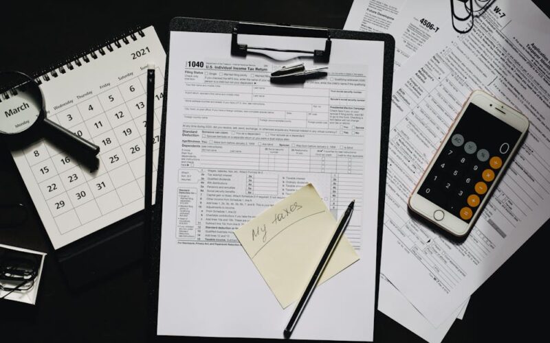 declaração do Imposto de Renda 2026 — High angle view of tax forms, calculator, calendar, and pen for financial planning.
