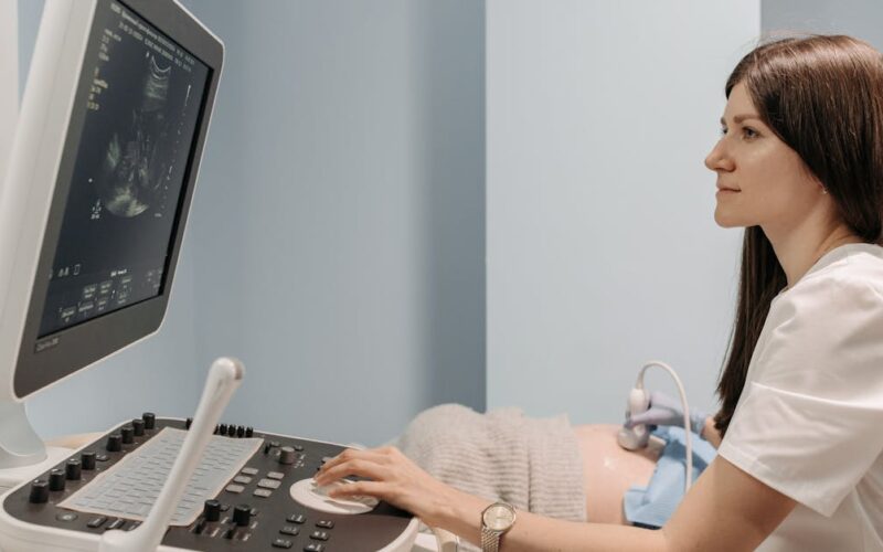 função do apêndice — A female doctor conducting an ultrasound examination in a medical clinic, focusing on patient care.