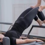 deduzir gastos com saúde IR — Women engaging in reformer Pilates with assistance in a Shenzhen studio promoting healthy lifestyle.