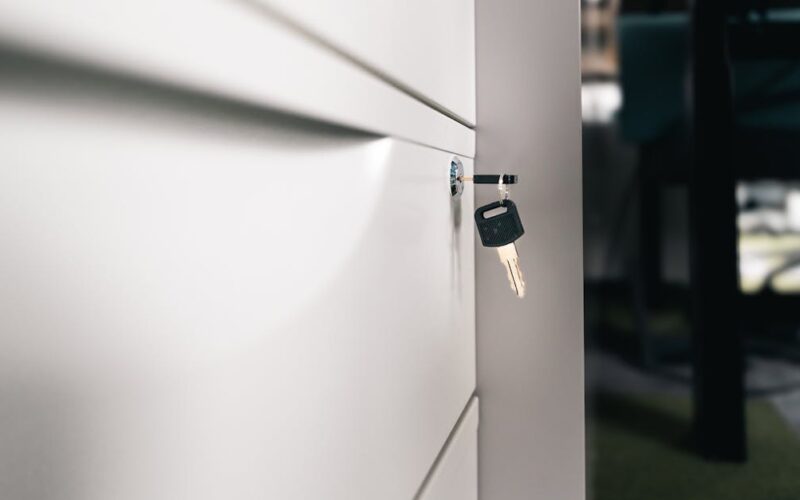 organizar documentos importantes — Close-up of a key in a locked office drawer for secure storage and privacy.