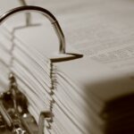 documentos para emergências — Detailed sepia close-up of a binder filled with documents, emphasizing texture.