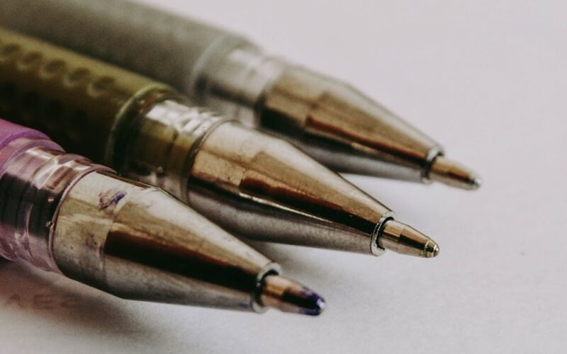 escrever com clareza — Macro photo showcasing the precision of three ballpoint pen tips in focus on paper.