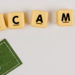 golpes IPTV ilegal — A minimal flat lay of a scam concept using dice and fake currency on a gray surface.