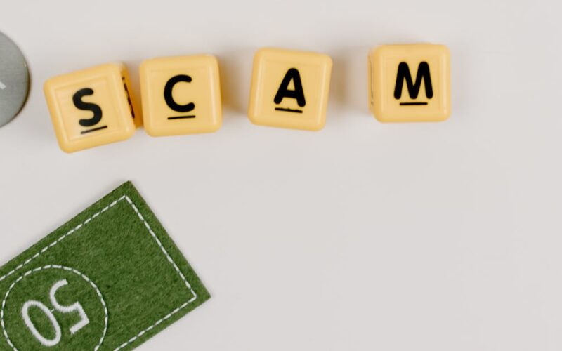 golpes IPTV ilegal — A minimal flat lay of a scam concept using dice and fake currency on a gray surface.