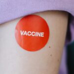 prevenir o surto de sarampo — A person's arm with a red vaccine sticker, symbolizing vaccination.