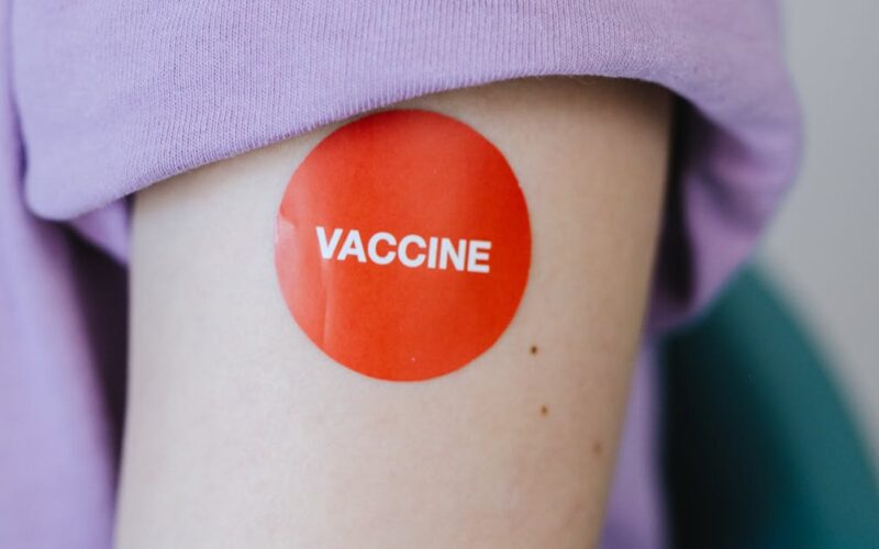 prevenir o surto de sarampo — A person's arm with a red vaccine sticker, symbolizing vaccination.