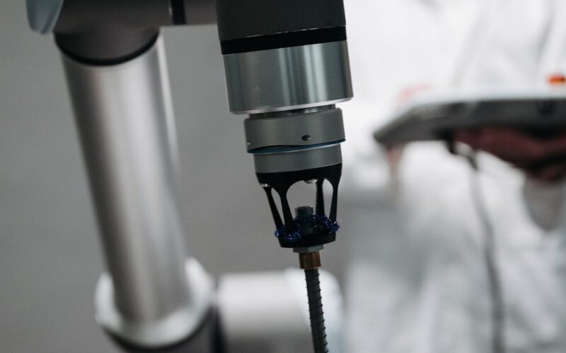 tecnologia robótica reabilitação AVC — Close-up of a robotic arm providing a back massage, supervised by an adult scientist.