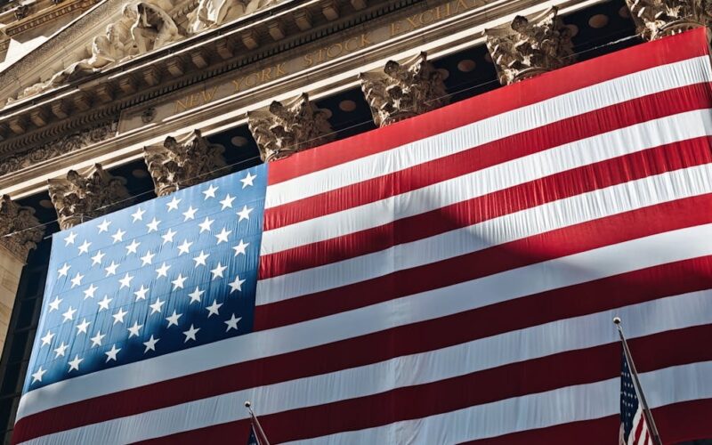 investir mercado americano — American flag adorning the iconic New York Stock Exchange building facade.