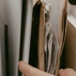 organizar documentos pessoais — Hands arranging papers and notebooks in a box, highlighting organization and office work.