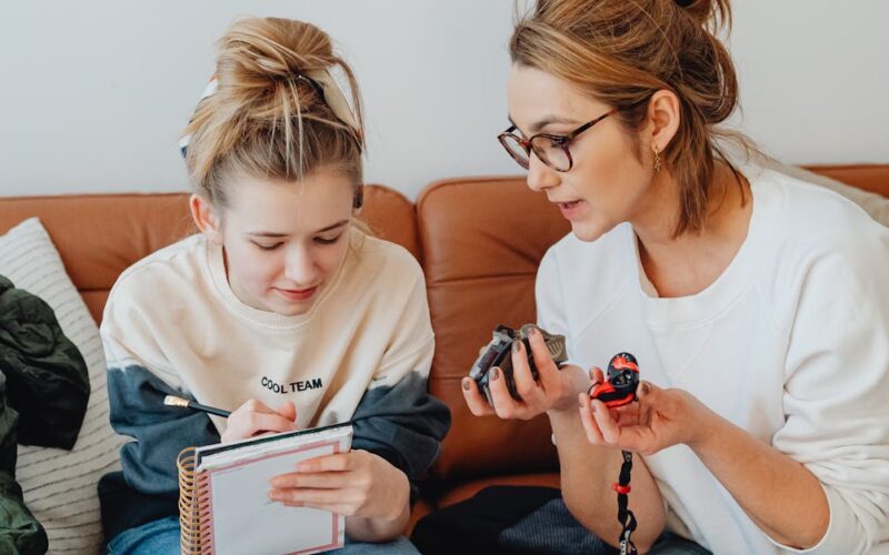 feriados prolongados viagens curtas — A mother and daughter planning a trip with a map and notebook in a cozy living room.