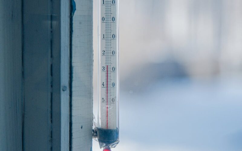 onda de frio 2026 — Close-up of an outdoor thermometer against a frosty winter backdrop.