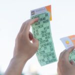 planejar uso do prêmio Mega-Sena — Close-up of hands holding transportation tickets, showcasing numbers and fare details.