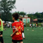 renovação seleção italiana futebol — Young kids playing soccer on a green field during the day. Engaged in a fun sporting activity.
