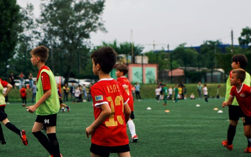 renovação seleção italiana futebol — Young kids playing soccer on a green field during the day. Engaged in a fun sporting activity.