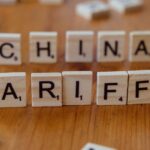comércio internacional do Brasil tarifas EUA — Scrabble tiles spelling 'China' and 'Tariffs' symbolize global trade issues.