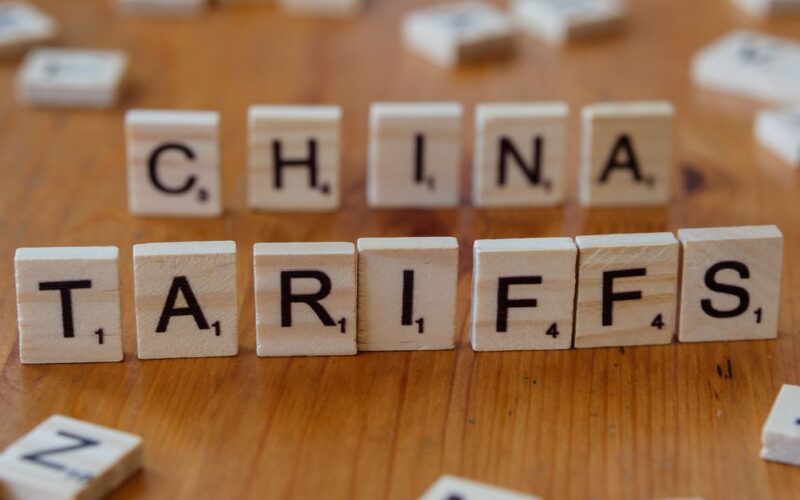 comércio internacional do Brasil tarifas EUA — Scrabble tiles spelling 'China' and 'Tariffs' symbolize global trade issues.
