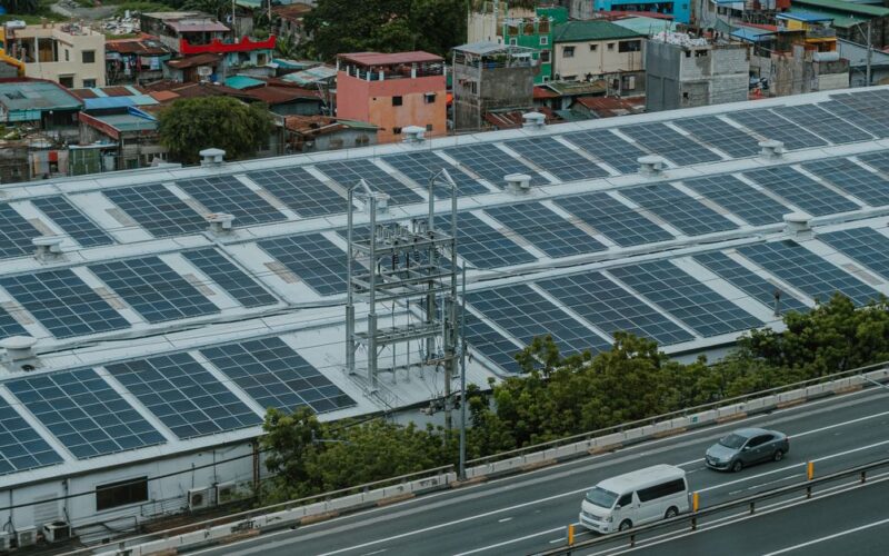 energia solar em rodovias — Urban landscape with solar panels and highway, showcasing renewable energy and modern infrastructure.