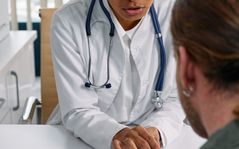 cuidados na trombofilia — Female doctor discusses health chart with patient during consultation in office setting.