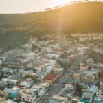 impactos sociais e ambientais copa 2026 — A beautiful aerial view of a city with colorful buildings and hills at sunset, capturing urban charm.