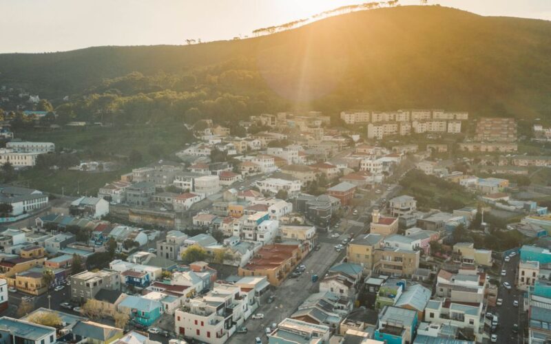impactos sociais e ambientais copa 2026 — A beautiful aerial view of a city with colorful buildings and hills at sunset, capturing urban charm.